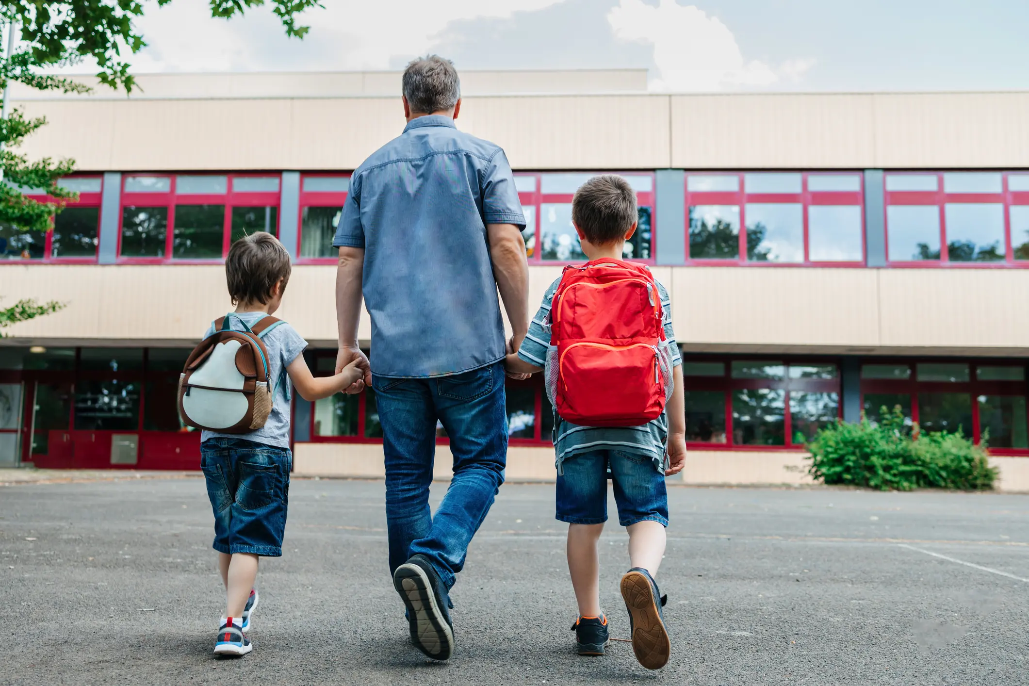 Man walking with two kids to school