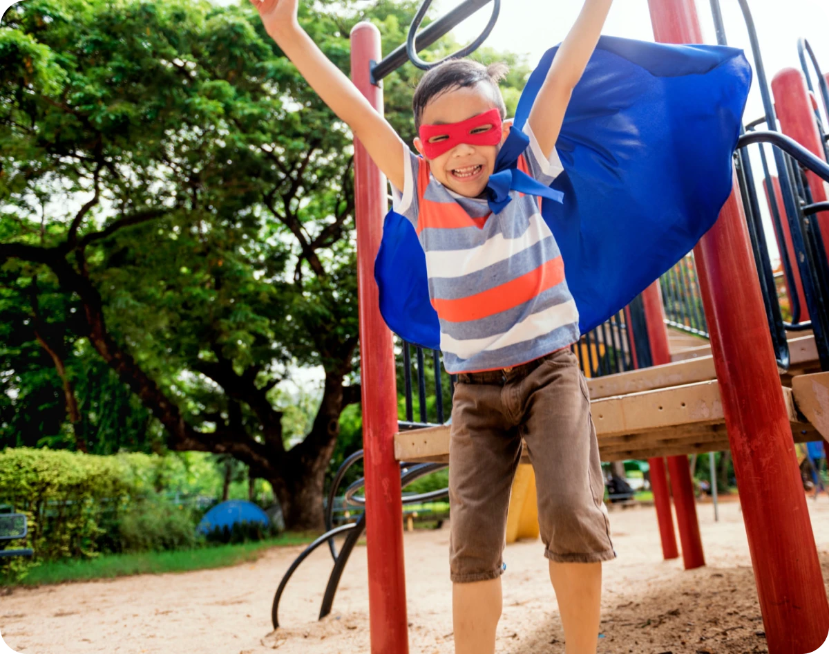 Boy with cape enjoying playground
